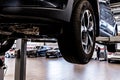 Car mechanic checks car on lift on Service station.