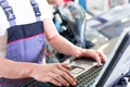 Car mechanic with diagnosis tool in auto workshop Royalty Free Stock Photo