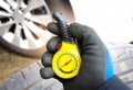 Car mechanic or driver checks tire pressure with a car tire pressure gauge. Royalty Free Stock Photo