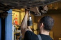 Car Mechanic Fixing Tie Rod and Steering System While Being Under the Vehicle. Car Maintenance in the Professional Royalty Free Stock Photo