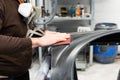 Car mechanic grinds a car part in handicraft in a service station - Serie car repair workshop