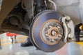 Car mechanic hands inspecting a shock absorber in vise at repair service. Garage room