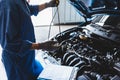 Car mechanic holding checking gear oil to maintenance vehicle by customer claim order in auto repair shop garage. Engine repair Royalty Free Stock Photo