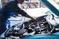 Car mechanic holding clipboard and checking to maintenance vehicle by customer claim order in auto repair shop garage. Engine Royalty Free Stock Photo