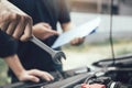 Car mechanic is holding a wrench ready to check the engine and maintain it with the assistant Royalty Free Stock Photo