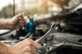 Car mechanic is holding a wrench ready to check the engine and maintenance Royalty Free Stock Photo