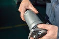 A car mechanic holds a fuel filter in his hands