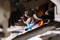 Car mechanic inspecting car wheel and repair suspension detail. Lifted automobile at repair service station. replacement Royalty Free Stock Photo