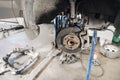 Car mechanic inspecting car wheel and repair suspension detail. Lifted automobile at repair service station. replacement