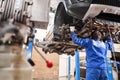 Car mechanic inspecting car steering rod and repair suspension detail. Lifted automobile at repair service station