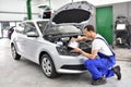 Car mechanic inspects vehicle in a workshop