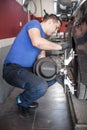 Wheel alignment. Car mechanic installing sensor during suspension adjustment Royalty Free Stock Photo