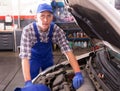 Car mechanic looking at open car hood for internal checking
