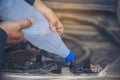 Car Mechanic man hands pouring Deionized purified Distilled water for car battery mechanical service. Close up hands man hold