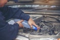 Car Mechanic man hands pouring Deionized purified Distilled water for car battery mechanical service. Close up hands man hold