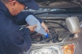 Car Mechanic man hands pouring Deionized purified Distilled water for car battery mechanical service. Close up hands man hold