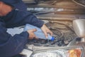 Car Mechanic man hands pouring Deionized purified Distilled water for car battery mechanical service. Close up hands man hold