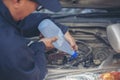 Car Mechanic man hands pouring Deionized purified Distilled water for car battery mechanical service. Close up hands man hold