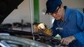 Car mechanic performing repair job at garage and car maintenance service station Royalty Free Stock Photo