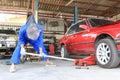 Car mechanic putting hydraulic jack under the car for repairing in auto repair service