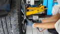 A car mechanic is removing wheel using an air impact Royalty Free Stock Photo