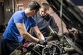 Car mechanic repairer service technician checks and repairs auto engine