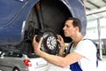 Car mechanic repairs brakes of a vehicle on the lifting platform Royalty Free Stock Photo