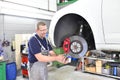 car mechanic repairs brakes of a vehicle on the lifting platform in a workshop Royalty Free Stock Photo