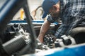 Car mechanic repairs a classic car inside his workshop Royalty Free Stock Photo