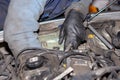 Car mechanic repairs diesel engine. Old and dirty car engine with car mechanics hands. Car repairing concept in the garage Royalty Free Stock Photo