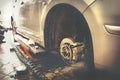 Car mechanic replace car wheels of lifted automobile by pneumatic wrench at repair service shop garage station