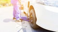 The car mechanic replacing flat tires on the road. Blue hydraulic car floor jacks lift the cars and wheel wrench placed nearby