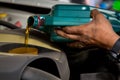 Car mechanic replacing and pouring fresh oil into engine at maintenance repair service station, Mechanic pouring oil into car at t Royalty Free Stock Photo