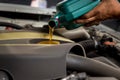 Car mechanic replacing and pouring fresh oil into engine at maintenance repair service station, Mechanic pouring oil into car at t Royalty Free Stock Photo