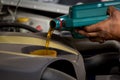 Car mechanic replacing and pouring fresh oil into engine at maintenance repair service station, Mechanic pouring oil into car at t Royalty Free Stock Photo