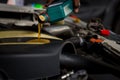 Car mechanic replacing and pouring fresh oil into engine at maintenance repair service station, Mechanic pouring oil into car at t Royalty Free Stock Photo