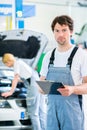 Car Mechanic team working in auto workshop Royalty Free Stock Photo