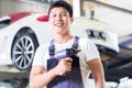Car mechanic with tool in Asian Chinese auto workshop Royalty Free Stock Photo