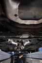 Car mechanic under a car in a repair shop/car garage