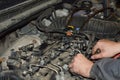 Car mechanic unscrews the fuel ramp on the engine Royalty Free Stock Photo