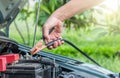 A car mechanic uses battery jumper cables to charge a dead battery Royalty Free Stock Photo