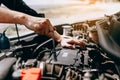 The car mechanic uses a wrench to open the car`s engine box