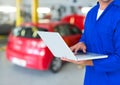 Car mechanic using laptop in repair garage Royalty Free Stock Photo