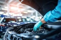 Car mechanic working in auto repair service. Closeup of male hands in gloves repairing car engine, Selective focus hands in gloves Royalty Free Stock Photo