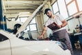 Car mechanic working in auto repair service using laptop Royalty Free Stock Photo