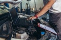 Car mechanic working in auto repair service using laptop Royalty Free Stock Photo