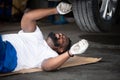 Car mechanic working in an auto repair shop, Check the operation of the engine of under the car Royalty Free Stock Photo