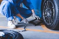 Car mechanics changing tire at auto repair shop garage. Transportation and Business working people concept. Automobile technician