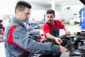 Car mechanics working at automotive service center Royalty Free Stock Photo