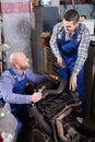 Car mechanics working at carshop